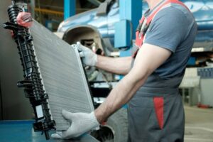 In the hands of an auto mechanic, an automobile radiator